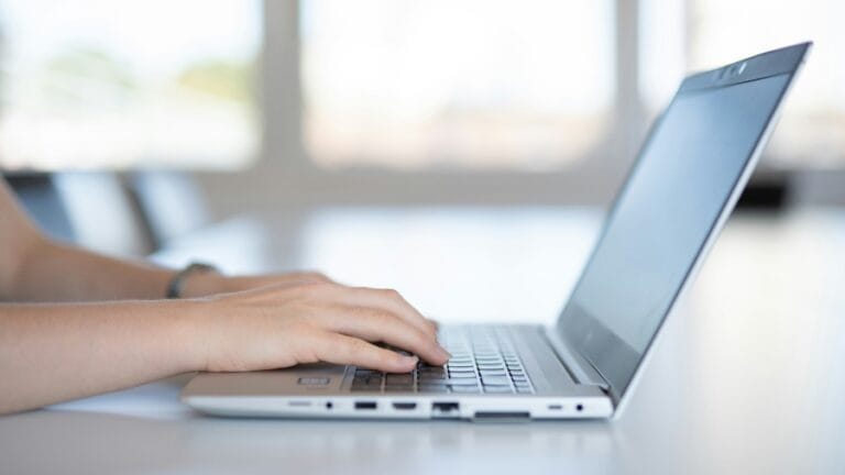 Ruke koje kucaju na tastaturi prenosnog računara